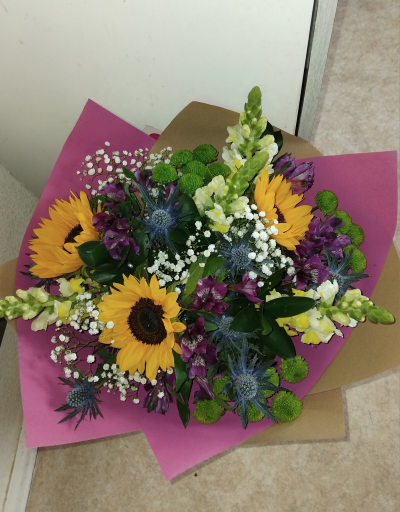 Bright Ideas - Beautiful Sunflowers and a peppering of other summer flowers and foliage. Tied in water and presented in a stylish bag. An amazing bouquet full of joy and delight ready to display and enjoy.