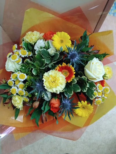 Sunshine surprise - A bright handtied of cheery flowers in water containing yellow, orange,and blues